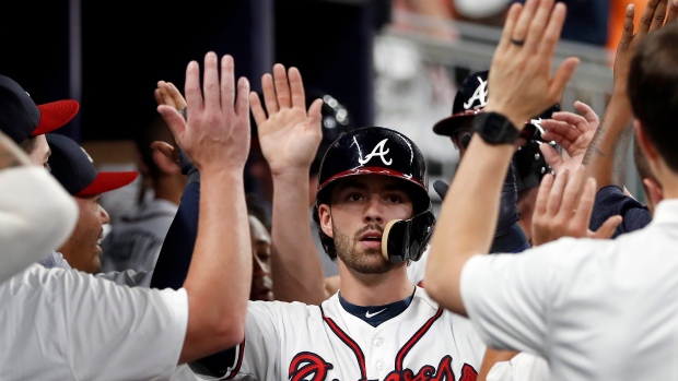 Atlanta Braves' Dansby Swanson (7) celebrates with bench coach