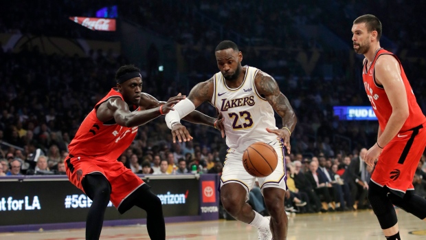 LeBron James (23) dribbles between Pascal Siakam, left, and Marc Gasol