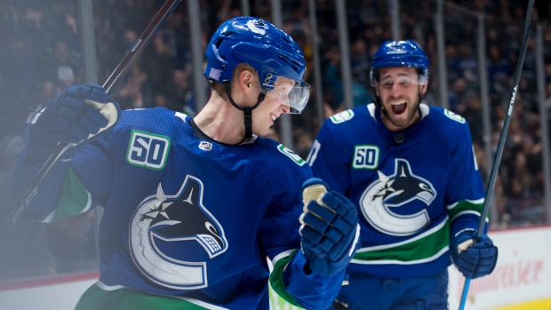 Elias Pettersson (40) celebrates with teammate Josh Leivo 