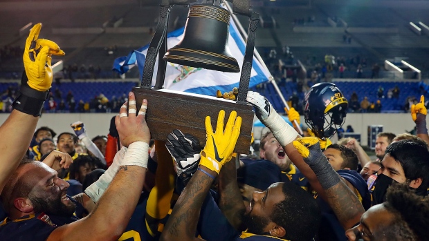 West Virginia players hoist the Liberty Bowl trophy