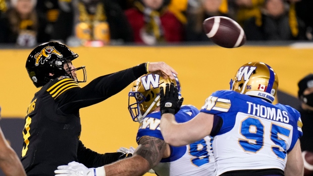 BC Lions' Justin McInnis (18) is tackled by Hamilton Tiger-Cats