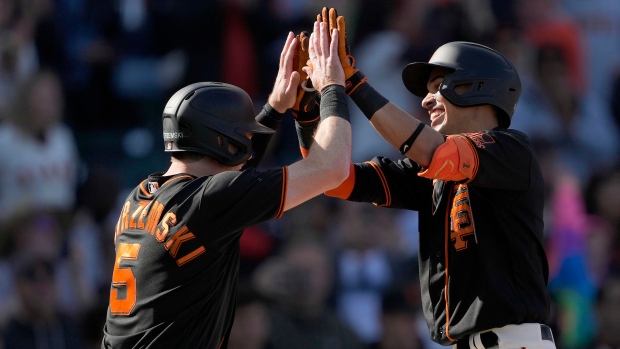 Wilmer Flores of the San Francisco Giants scores against catcher