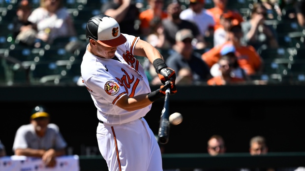 Ryan Mountcastle of the Baltimore Orioles laughs after swinging at