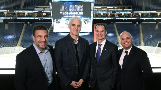 Los Angeles Kings president Luc Robitaille, centre, smiles at a news conference