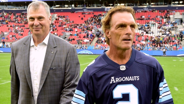 NFL quarterback Doug Flutie shows off his jersey during a ceremony